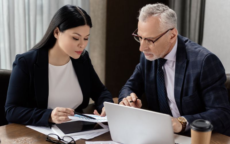 Two accounting professionals  evaluate the records to make sure it's accurate in IC-DISC export books.