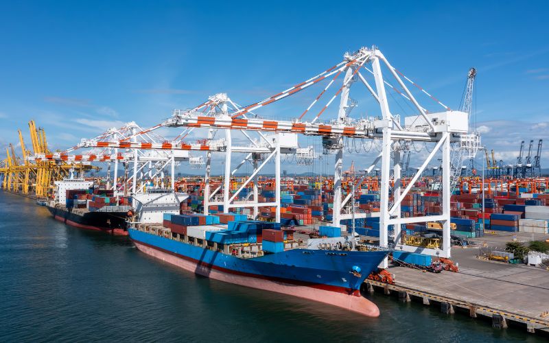 A large container ship at a port, representing the logistics of exporting goods