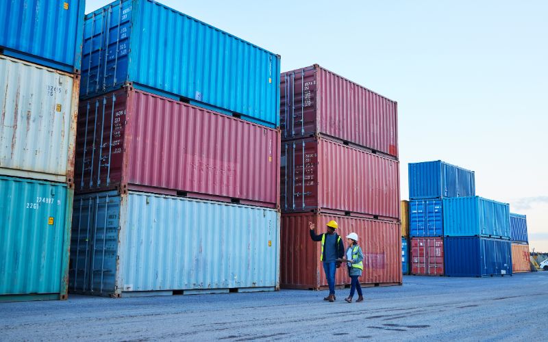 Two individuals checking the shipping containers before exporting it.