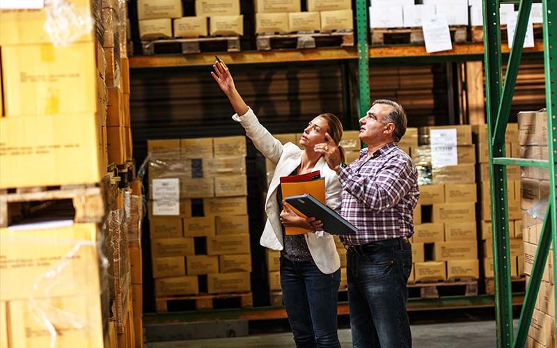 Two export expert in a warehouse inspecting an item, highlighting the competitive advantages of IC-DISC benefits.